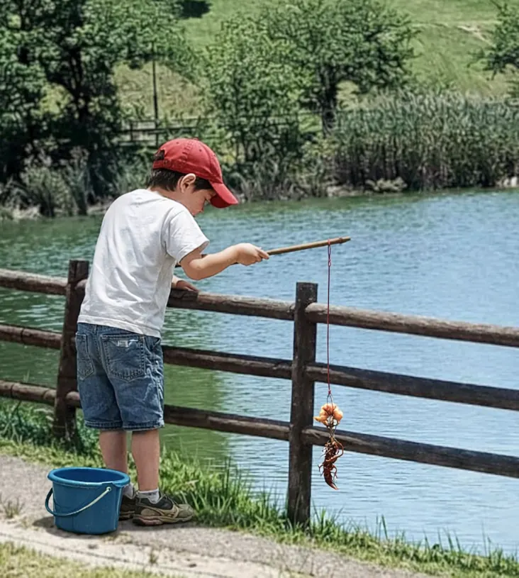 新海池公園でザリガニの釣果を得た少年.webp