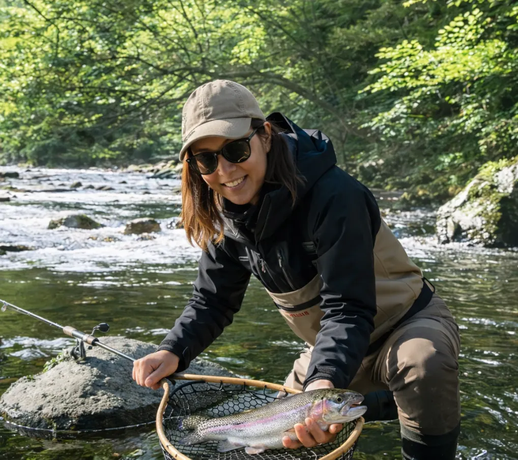 美幌川でニジマスの釣果を得た女性.webp