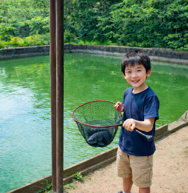 緑水園でコイの釣果を得た少年.webp